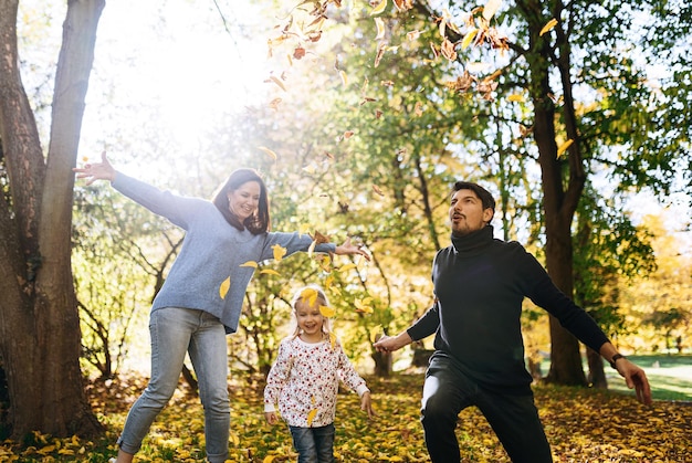 Família feliz com filha no parque outono recreação ao ar livre