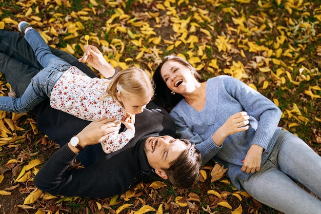 Família feliz com filha no parque outono recreação ao ar livre