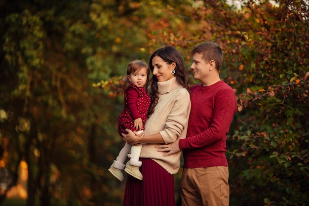 Família feliz com filha se divertindo em um passeio no parque