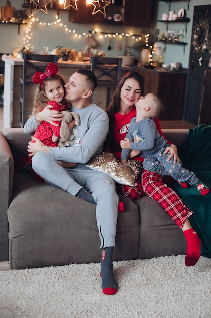 Família feliz com filhos relaxando no dia de Natal