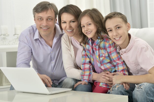 Família feliz com laptop em uma sala