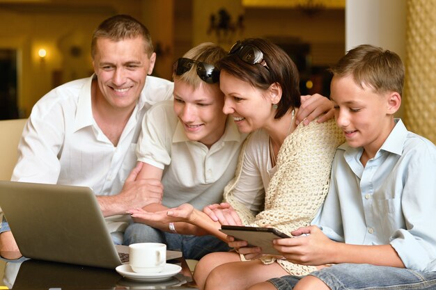 Família feliz com laptop na mesa