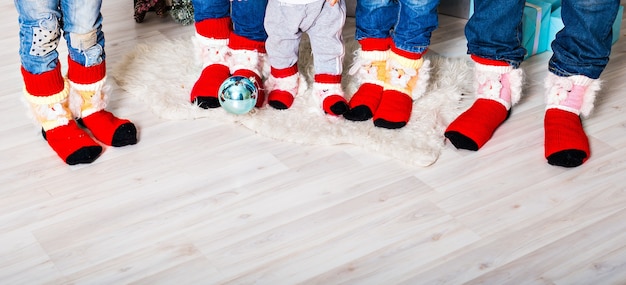 Foto família feliz com meias de natal. conceito de férias de inverno. tres filhos