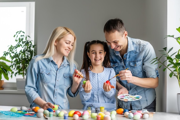 Família feliz com ovos de páscoa. família feliz se preparando para a páscoa.