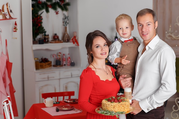 Família feliz com saboroso bolo de Natal na cozinha de fundo. Feriado de ano novo e diversão.