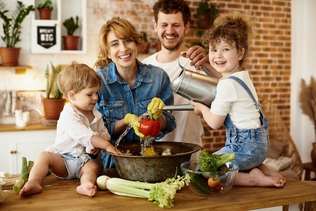 Família feliz com seus filhos cozinhando na cozinha