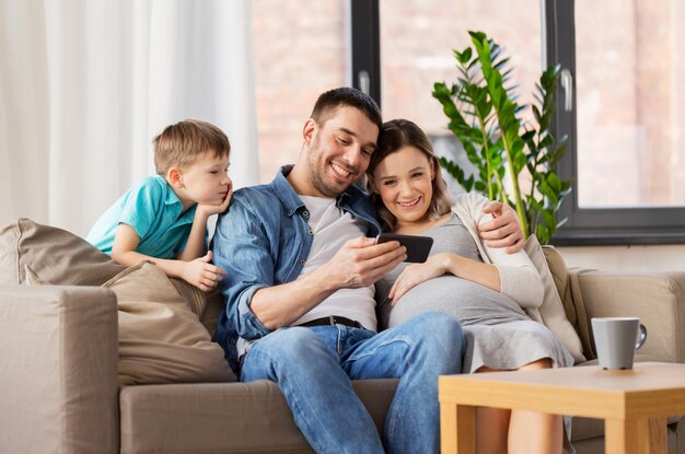 família feliz com smartphone em casa