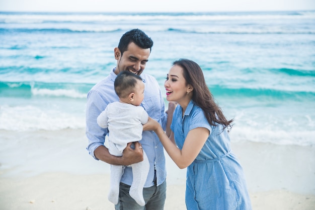 Família feliz com suas férias de filho bonito na praia