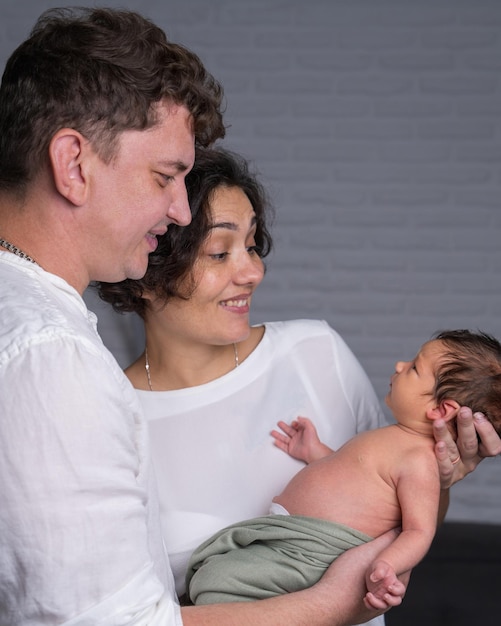 Foto família feliz com um bebê recém-nascido mãe e pai amorosos seguram ternamente seu filho em seus braços