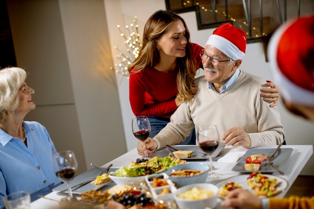 Família feliz comemorando ano novo à mesa em casa