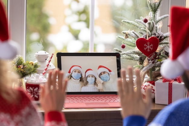 Família feliz comemorando o feriado de Natal online por bate-papo por vídeo em quarentena. Conceito de ficar em casa de bloqueio. Festa de Natal durante o coronavírus pandêmico COVID 19