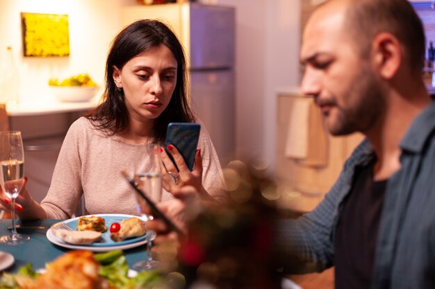 Família feliz comendo um delicioso jantar de natal sentado à mesa de jantar