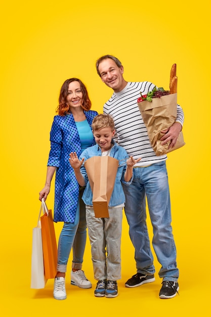 Foto familia feliz con comestibles durante las compras