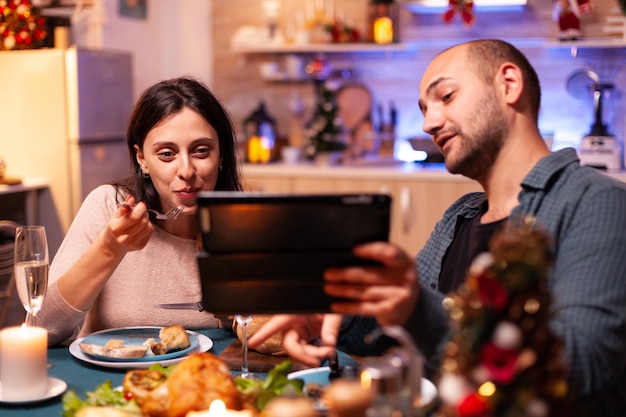 Familia feliz comiendo una deliciosa cena sentado en la mesa de comedor