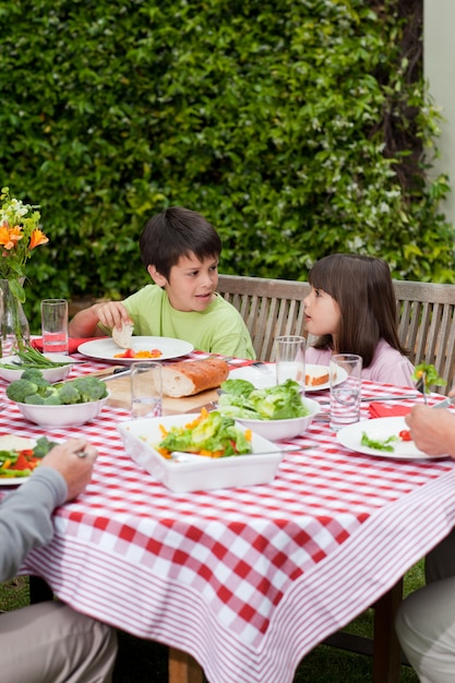 Familia feliz comiendo en el jardín