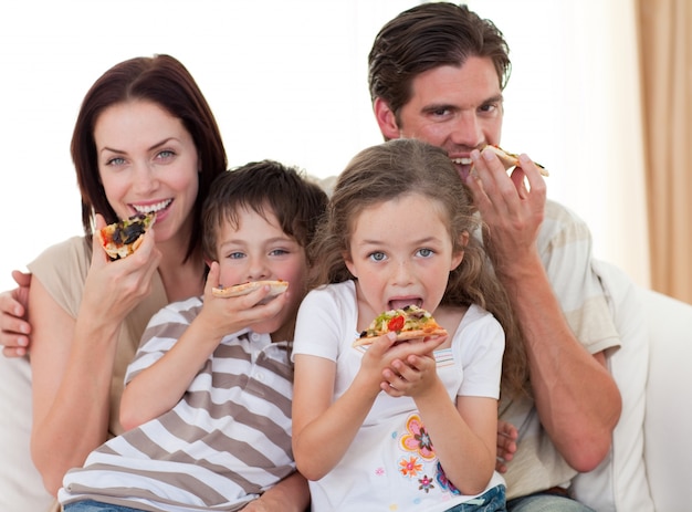 Foto familia feliz comiendo pizza