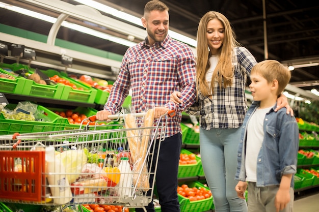 Familia feliz comprando comestibles en el supermercado