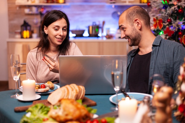 Família feliz comprando presente de natal usando cartão de crédito fazendo online