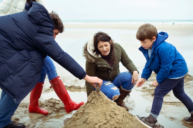 Família feliz, construindo um castelo de areia