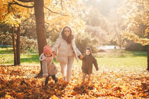 Família feliz correndo no parque amarelo de outono