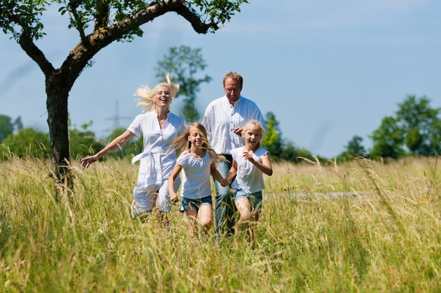 Familia feliz corriendo en el prado