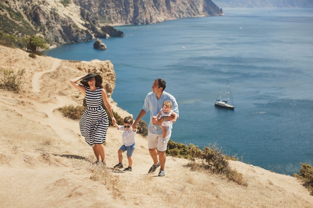 Familia feliz de cuatro caminando en las montañas