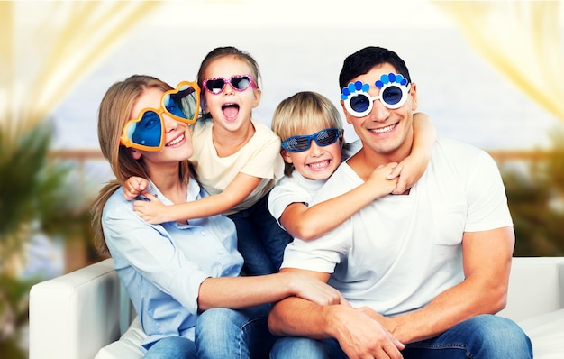 Familia feliz de cuatro con gafas graciosas sonriendo a la cámara