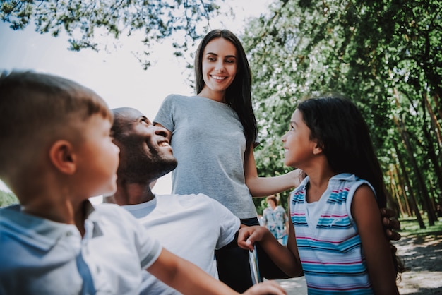 Familia feliz cuidando al hombre en silla de ruedas