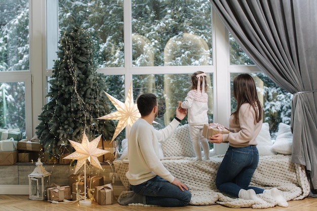 Família feliz da mãe, pai e filha passaram um tempo juntos na véspera do natal jovens