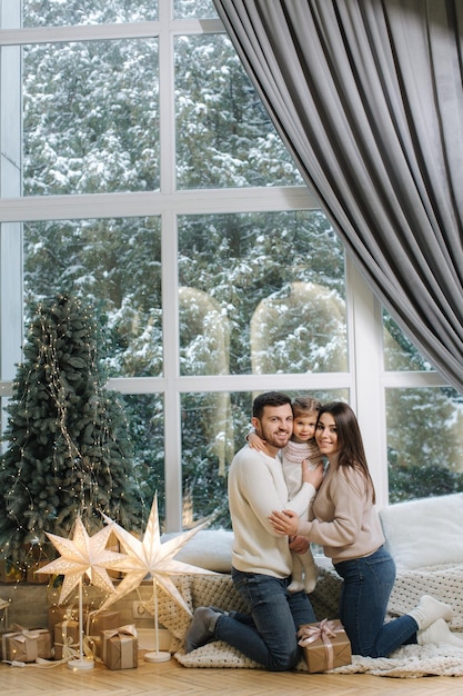 Família feliz da mãe, pai e filha passaram um tempo juntos na véspera do natal jovens