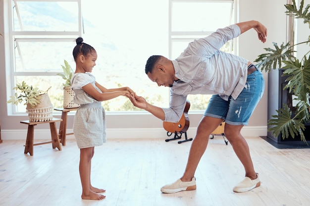 Família feliz dança e pai e filho de mãos dadas se unem e desfrutam de momentos divertidos e de qualidade juntos para o Dia dos Pais Ame a felicidade e o homem negro se curva para a menina enquanto dança, brincando e ensinando o jovem garoto