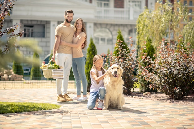 Familia feliz dando un paseo junto con su perro