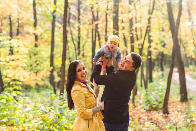 Família feliz de mãe, pai e bebê na natureza do outono