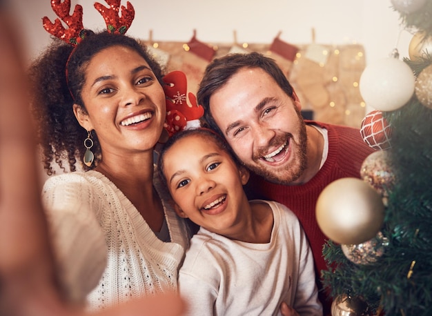 Foto família feliz de natal e selfie de retrato e engraçado juntos em casa sorriso de natal e rosto dos pais com menina interracial e mãe africana rindo com o pai para festa e feriado