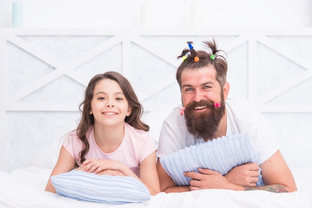 Família feliz de pai e filha se divertindo em casa com penteado engraçado dia dos pais