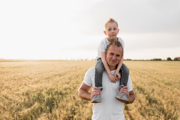 Família feliz de pai e filho andar em um campo de trigo.