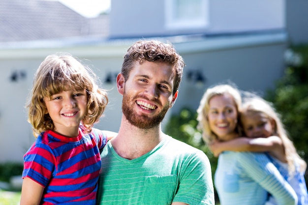 Família feliz, de pé contra a casa