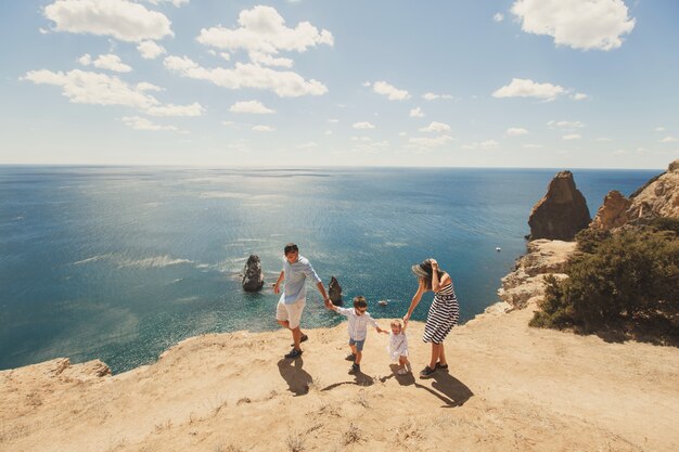 Família feliz, de quatro pessoas andando nas montanhas