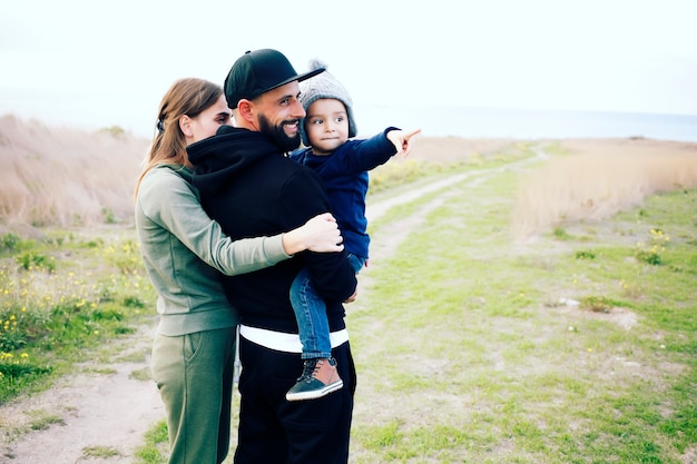 Família feliz de três pessoas se divertindo ao ar livre