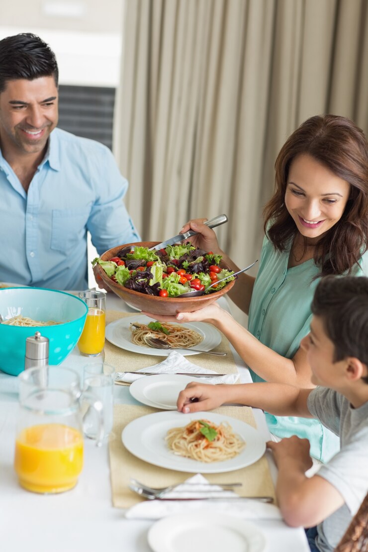 Foto família feliz de três sentados na mesa de jantar