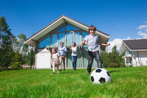 Família feliz de várias gerações jogando futebol juntos no parque