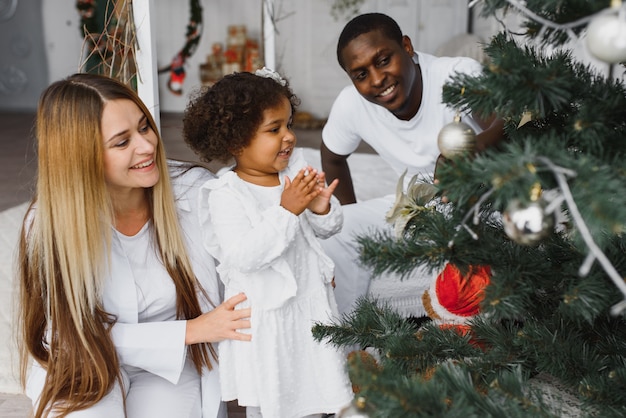 Família feliz decorando a árvore de natal