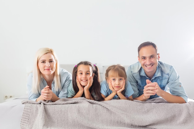 Família feliz deitada em uma cama no quarto