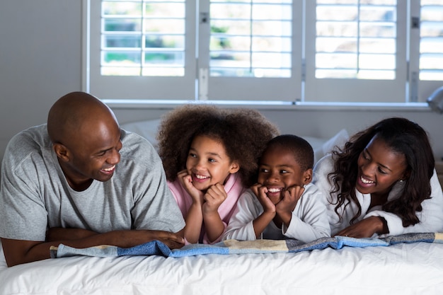 Família feliz, deitado na cama