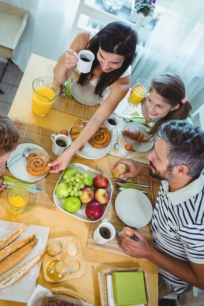 Familia feliz desayunando en casa