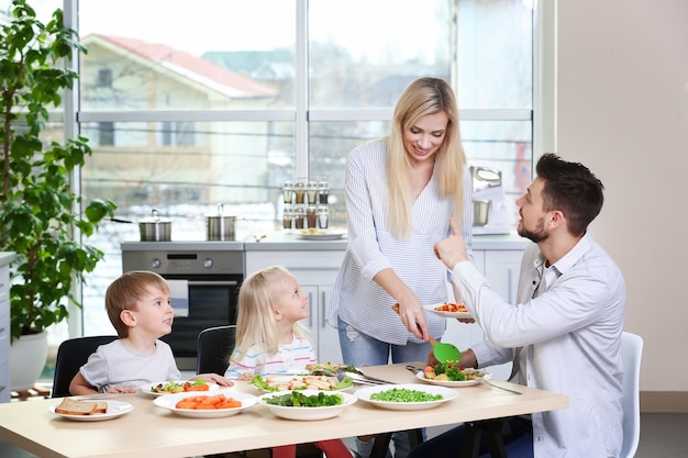 Familia feliz desayunando en casa