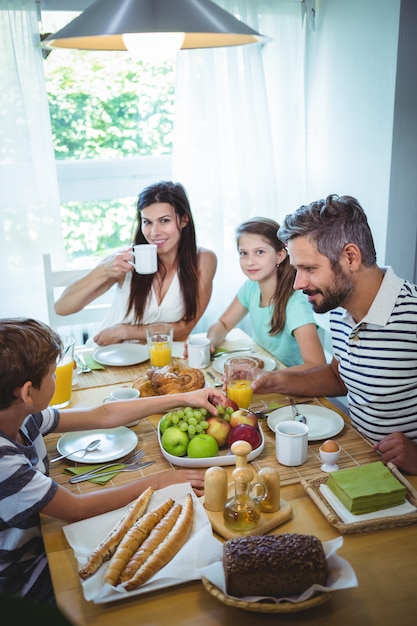 Familia feliz desayunando juntos