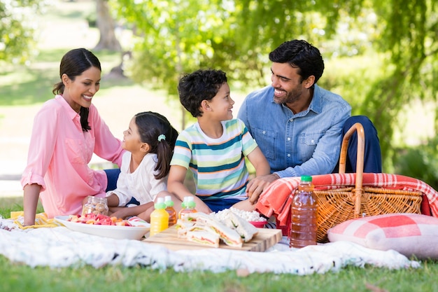 Familia feliz desayunando en un parque