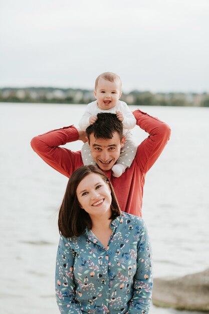 Foto família feliz, descansando à beira do lago