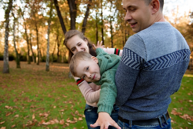 Familia feliz descansando en el hermoso parque de otoño